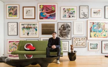 KAWS sitting in front of his extensive art collection : Photo by © Stefan-Ruiz