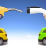 Automóvil eléctrico y auto concepto de gasolina. mano sosteniendo bomba de gasolina y conector para recarga de energía vía Shutterstock