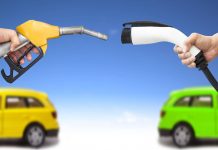 Automóvil eléctrico y auto concepto de gasolina. mano sosteniendo bomba de gasolina y conector para recarga de energía vía Shutterstock