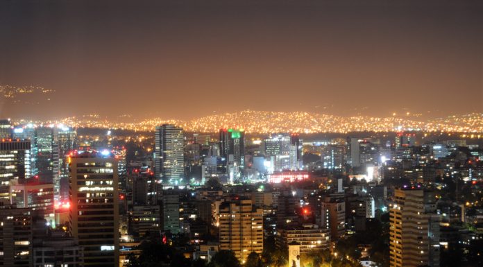 Es necesario descentralizar la Ciudad de México, aseguran urbanistas e historiadores Perspectiva nocturna del Centro Histórico de la Ciudad de México, con los suburbios iluminados en el fondo via Shutterstock
