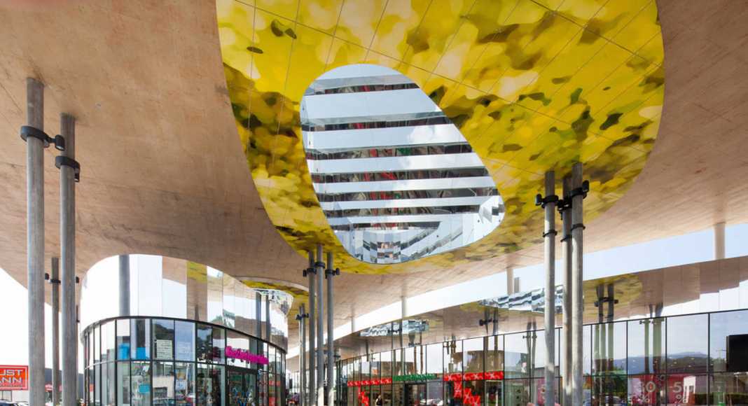 In a cone of natural light bench seats run around a number of columns : Photo credit © Markus Kaiser