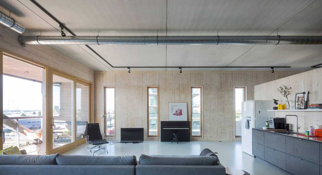 Apartment 9: an open floorplan appartment for a family with to teenage doughters. The structural wooden wall of the west facade is present in the complete space : Photo credit © Luuk Kramer