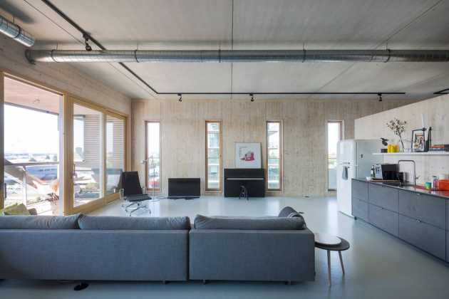 Apartment 9: an open floorplan appartment for a family with to teenage doughters. The structural wooden wall of the west facade is present in the complete space : Photo credit © Luuk Kramer