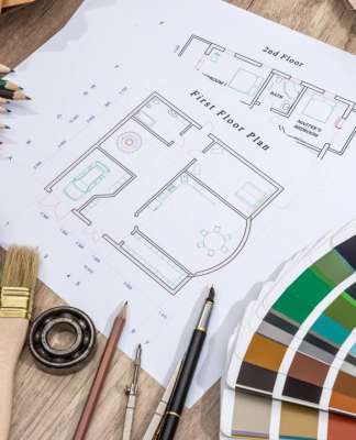 El impacto del color en el ser humano como elemento comunicante Drawing plan house with a palette of colors on wooden background vía © Shutterstock