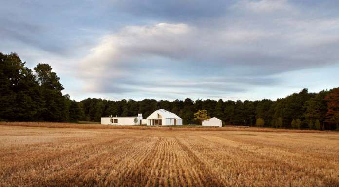 The house sits at the nexus of the land’s constituent characteristics: forests to the west, a hill to the south, and 100 acres of fields to the north and east : Photo credit © Ben Rahn / A-Frame Studio