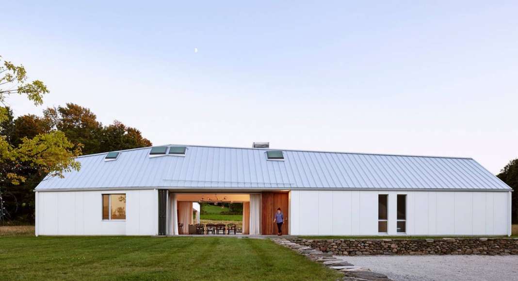 Landscape manipulations embed and connect the house to its site: constructed with fieldstone found on the property, low retaining walls create a foundational plinth for the house and an enhanced sectional dynamic : Photo credit © Ben Rahn / A-Frame Studio