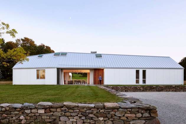 Landscape manipulations embed and connect the house to its site: constructed with fieldstone found on the property, low retaining walls create a foundational plinth for the house and an enhanced sectional dynamic : Photo credit © Ben Rahn / A-Frame Studio