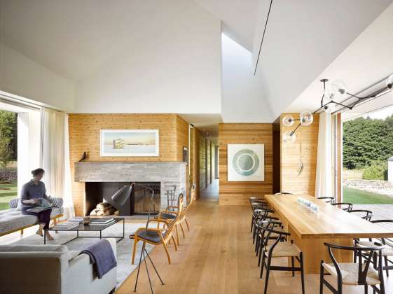 Inside, floors and walls made from white oak and knotty white cedar are textured and warm. In contrast, the ceiling above the main space is white, expansive and seemingly boundless. The distinct difference in materiality echoes the meeting of land and sky outside : Photo credit © Ben Rahn / A-Frame Studio