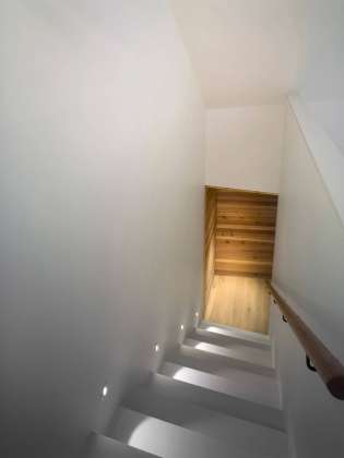 A hidden stair between the kitchen and principal bedroom suite connects the main space with a loft above : Photo credit © Ben Rahn / A-Frame Studio