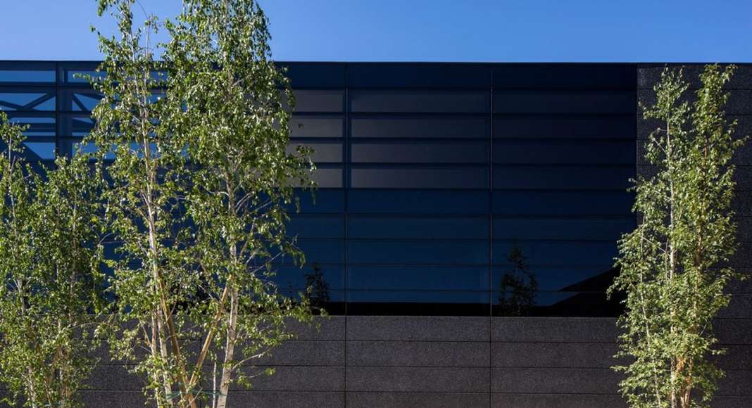 The building is covered in a ventilated skin made of black concrete and black glass : Photo credit © Massimo Crivellari