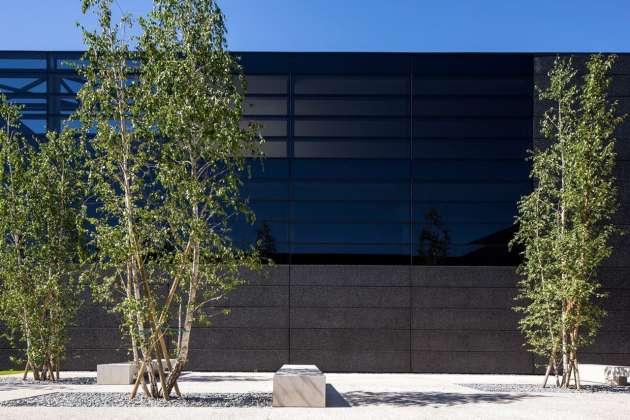 The building is covered in a ventilated skin made of black concrete and black glass : Photo credit © Massimo Crivellari