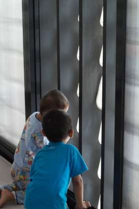 Children looking out through the ice cream bucket facade of Microlibrary Bima : Photo credit © Sanrok studio / SHAU