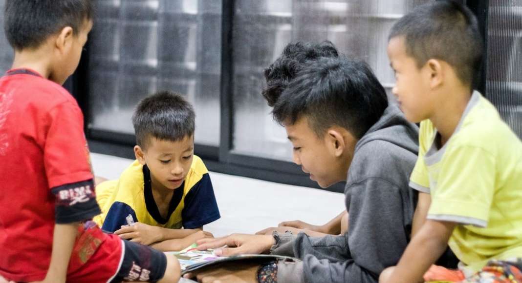 Children reading together inside Microlibrary Bima : Photo credit © Sanrok studio / SHAU