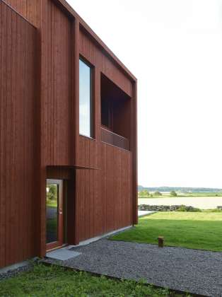 Entrance hall overlooking the countryside in the south. The façade is treated with a lighter version of Falu red colour. Plate details around windows, rails and screen ceilings are treated with the same color scale : Photo © Bornstein Lyckefors Arkitekter