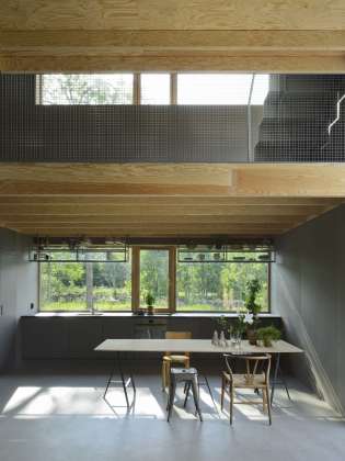 Kitchens and upper living room with slab ceilings. Light slides diagonally throughout the entire building. : Photo © Bornstein Lyckefors Arkitekter